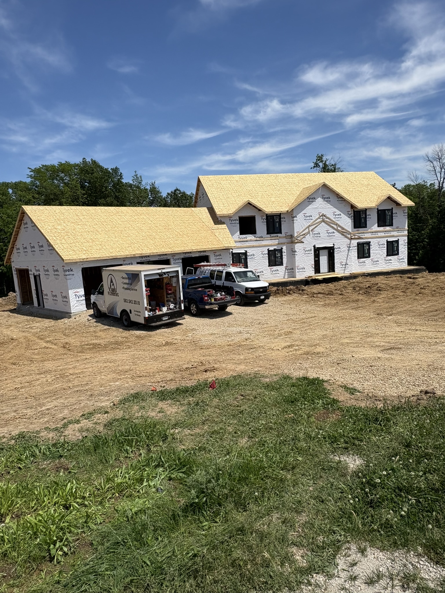 Finished custom home in Zwingle, Iowa, with white siding and black metal roof, built by NXT Build