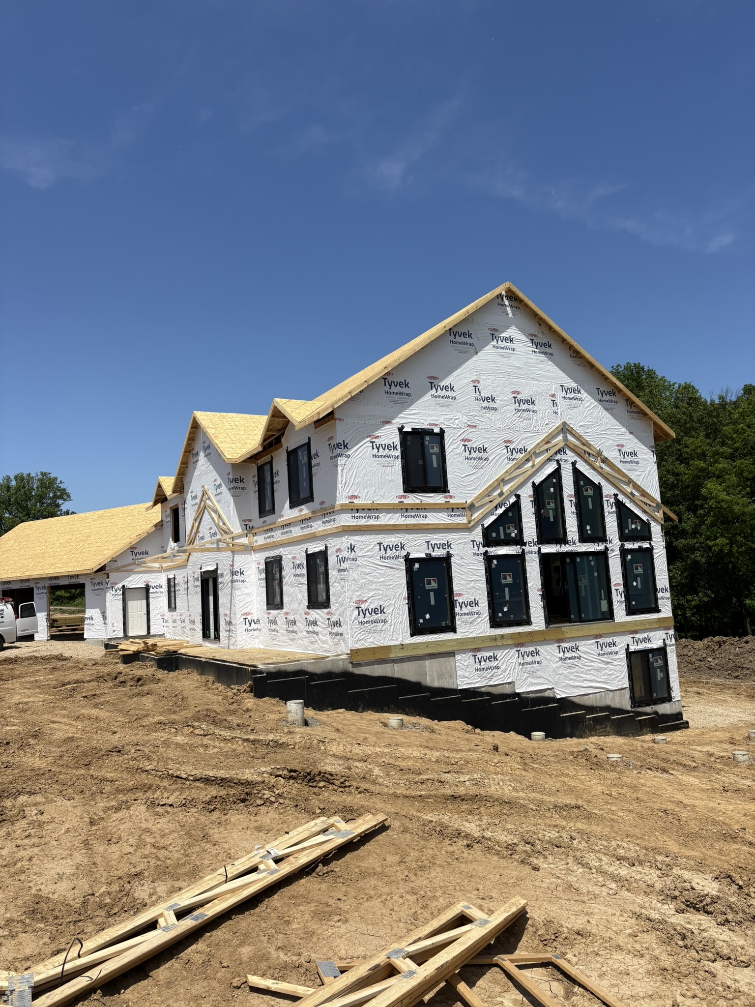 NXT Build custom home with dark vertical siding and stone wainscot in eastern Iowa